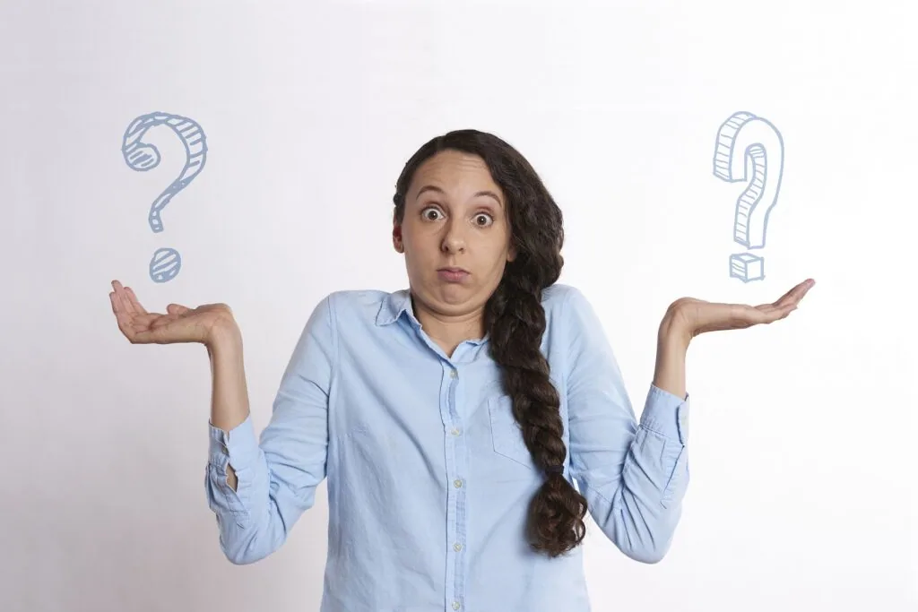 Woman in light blue shirt with hands raised in shrugging gesture, with sketched question marks floating on either side